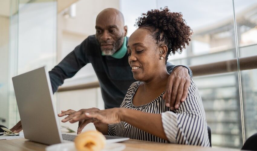Mature couple using laptop on kitchen counter