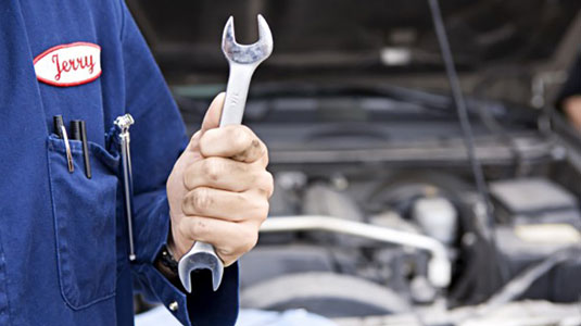 Car mechanic holding a tool