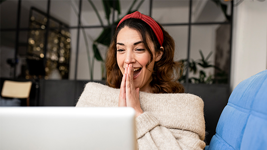 Excited woman looking at a laptop