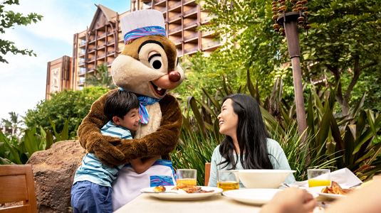 Image of Dale the chipmunk hugging a child at the dinner table.