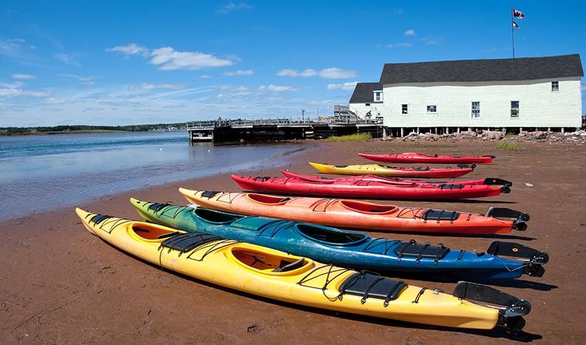 Colourful kayaks on a beach in North Rustico, Prince Edward Island.