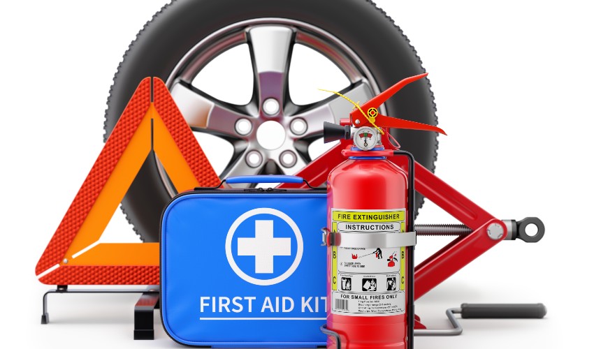 Car safety kit including a fire extinguisher, first aid kit, scissor jack and warning triangle and tire.