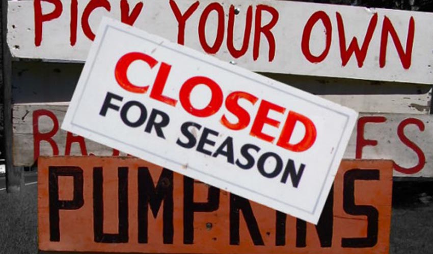 A sign at a fruit stand that says: "closed for season".