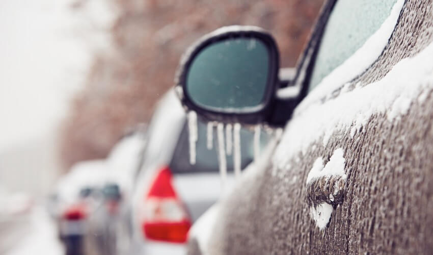 Close-up of car on the street covered by icy rain.