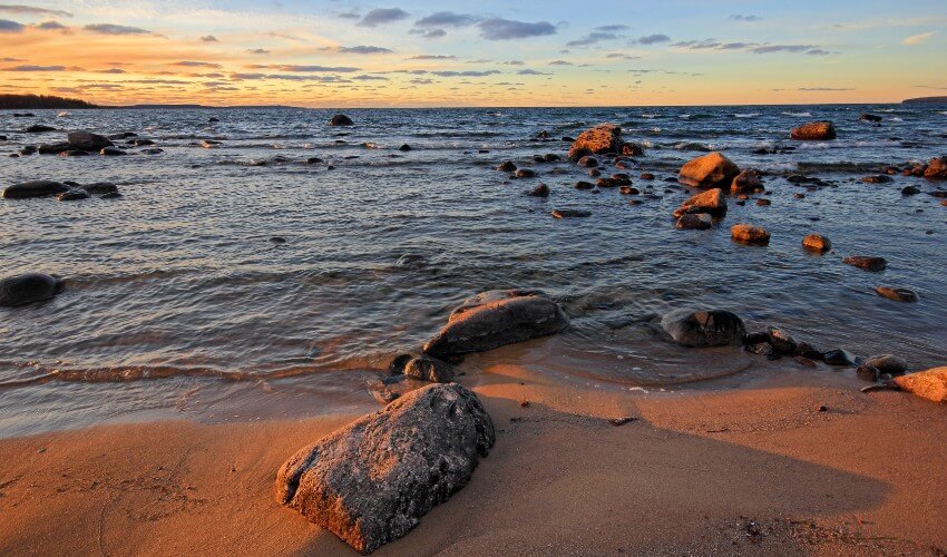 Scenic sand beach with rocks and waves in Georgian Bay, Awenda Provincial Park, Ontario, Canada.