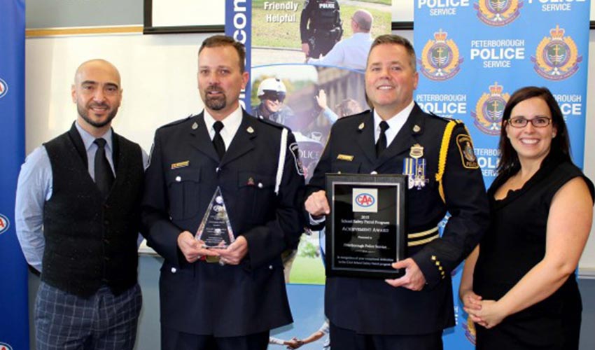 Two police officers are presented with the CAA School Safety Patrol Program Achievement Award.