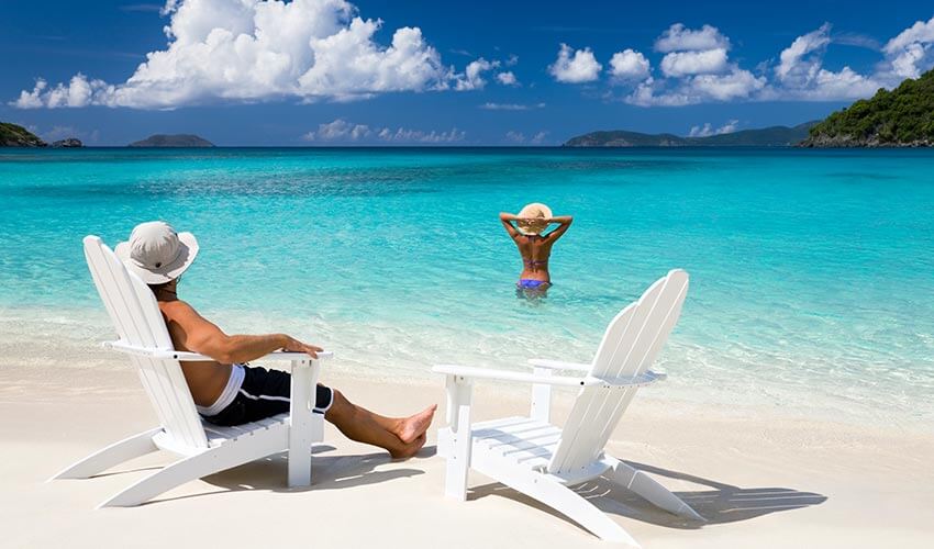 A couple enjoying the sun and blue ocean at a beach.