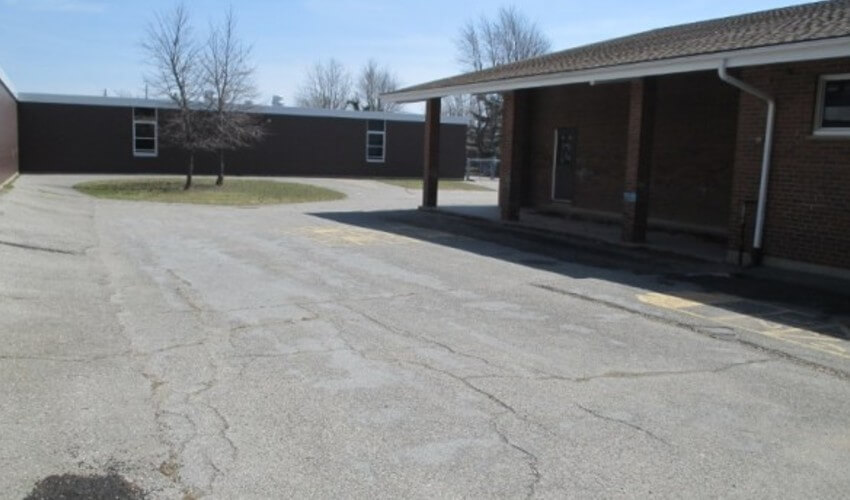 Before Elgin Court Public School courtyard updates showing cracks on pavement.