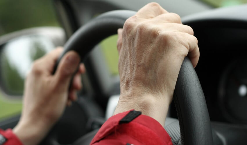 Senior’s hands on steering wheel.