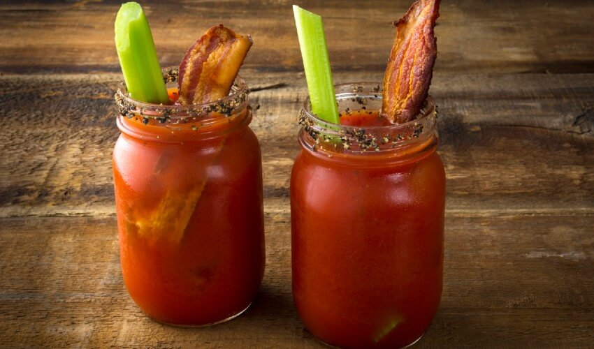 Bloody Caesar drink with a piece of bacon and celery.