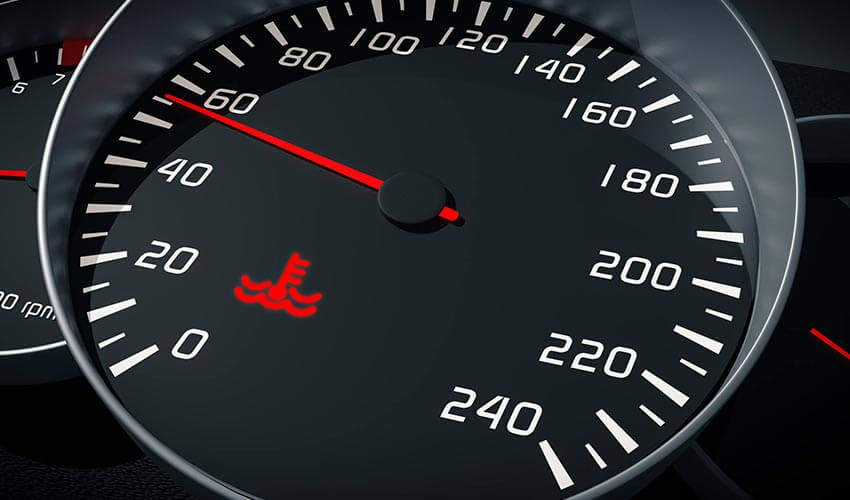 A speedometer in car with red coolant indicator being displayed.