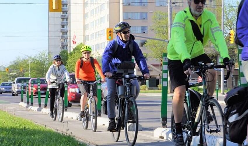 Cyclists riding in a row along a street.
