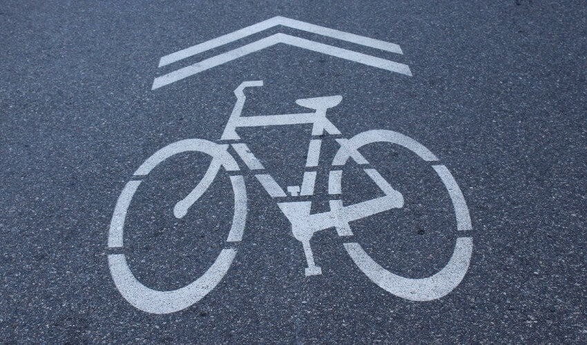 Sharrows white markings on a roadway for cyclists.