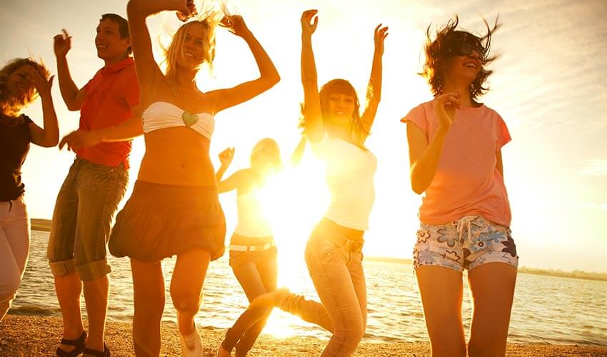 Young people dancing on a beach