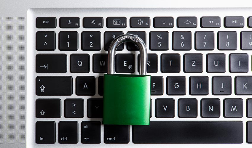 A pad lock placed on top of a laptop's keyboard.