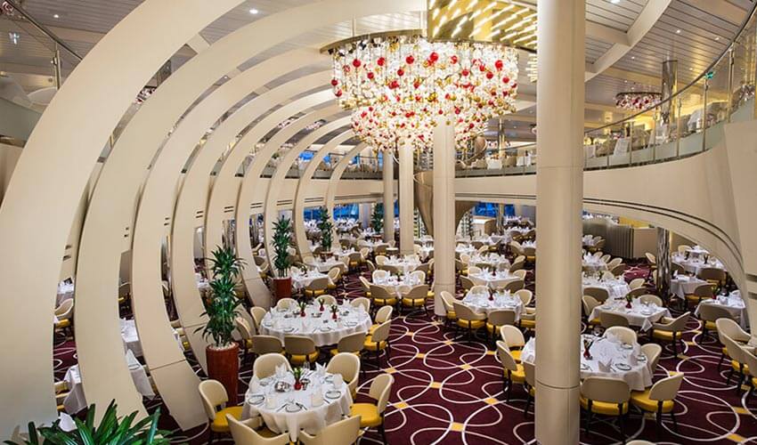 The dining room on the cruise ship with curved feature wall and tall ceilings. 