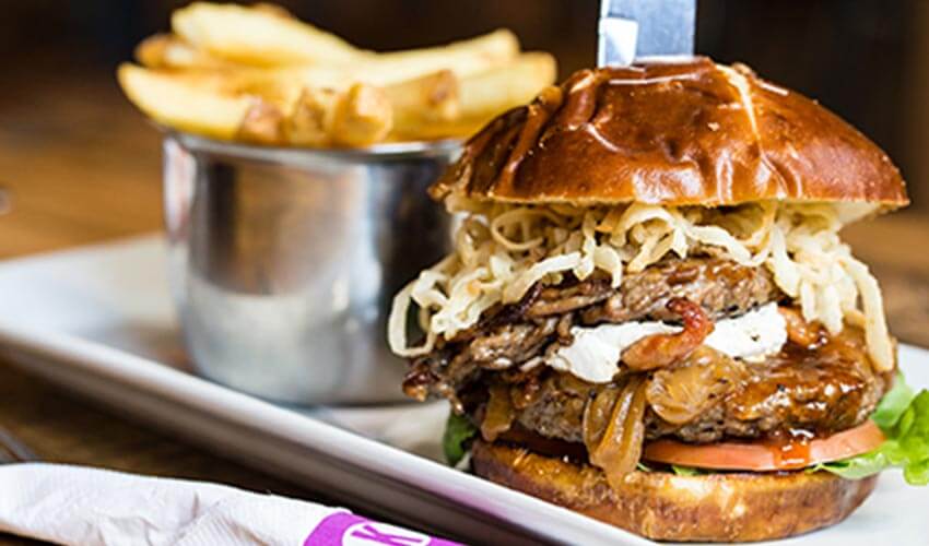 A large delicious burger and a side of fries on a plate
