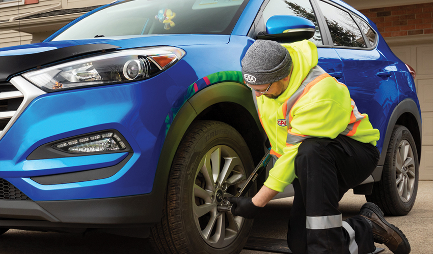 CAA technician changing winter tires in driveway