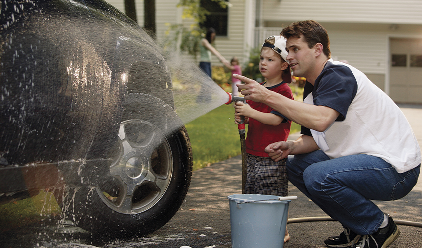 Father and son washing navy SUV