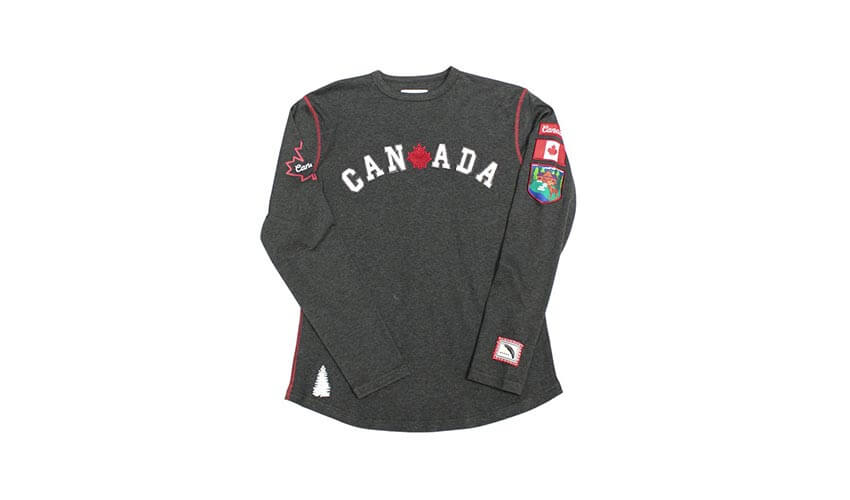 A women's grey long-sleeve shirt with the word "Canada" in the front and patches on the upper sleeve.