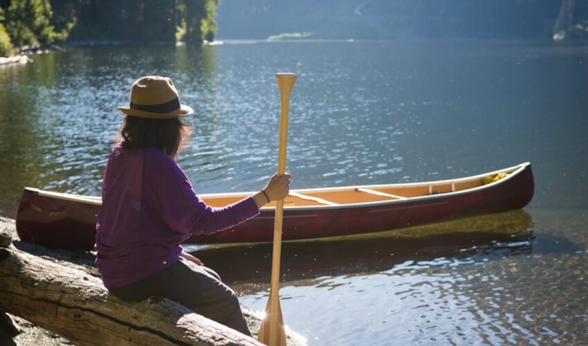 Female taking a break from canoeing to take in the stunning views.
