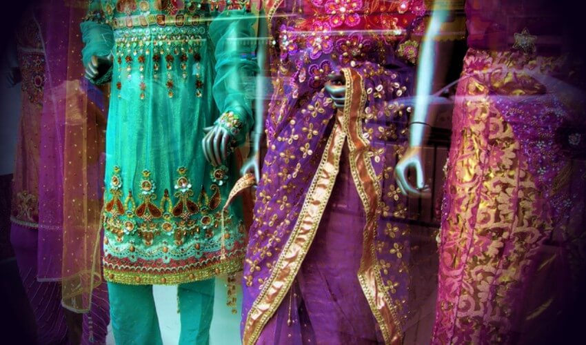 Colourful saris displayed in a shop window.
