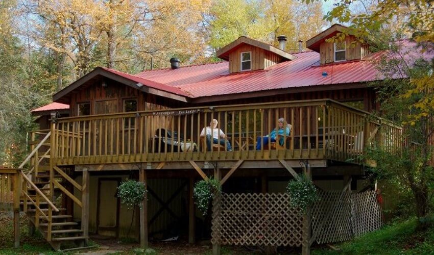 Two people sitting on a deck at Algonquin Eco-Lodge.