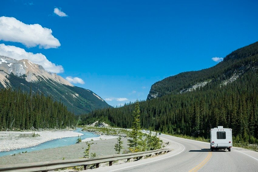 Recreational vehicle driving through the beautiful wilderness landscape of the Canadian Rockies in Banff National Park, Alberta, Canada.