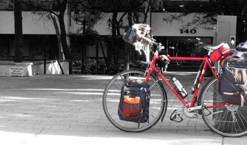 Red bike parked on a sidewalk outside a building