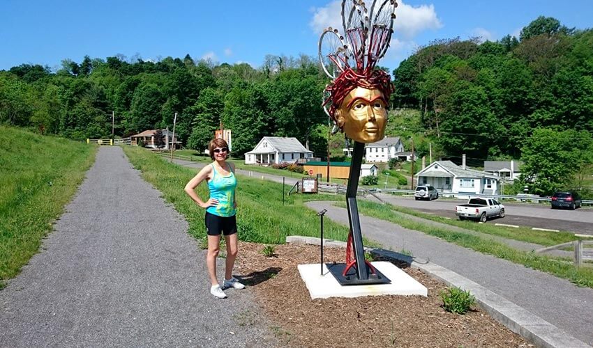 Vicky standing next to a large golden statue