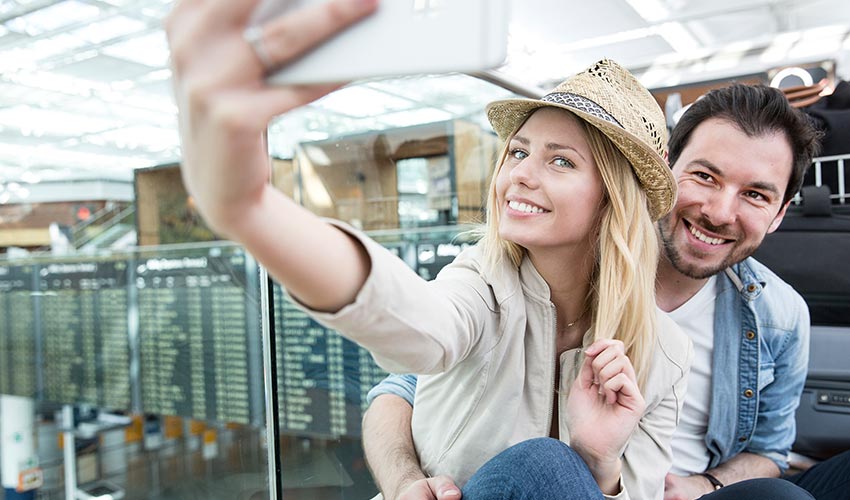 Couple taking a selfie in an airport.