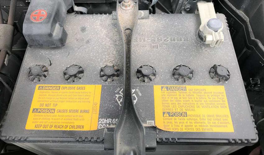 Top view of a dusty, old car battery.
