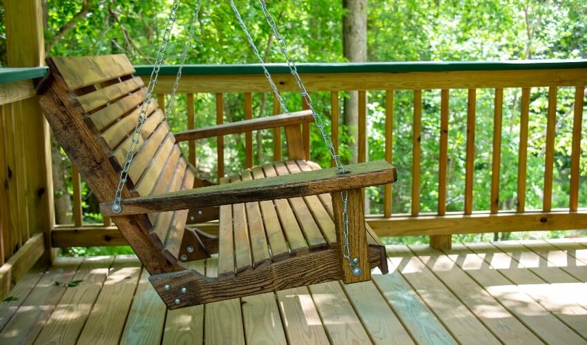 Wooden bench swing on the front porch.