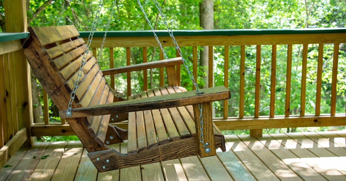 Wooden bench swing on the front porch.