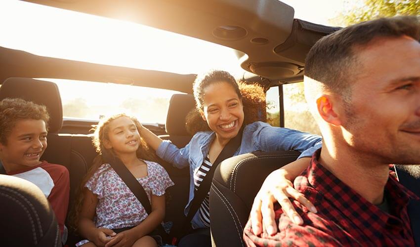 A family of four going on a trip in a car.