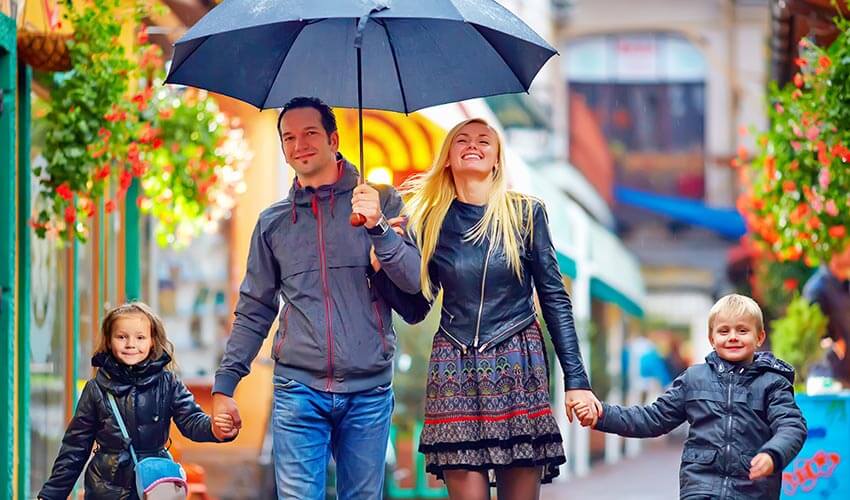 A family walking along a street on a rainy day.