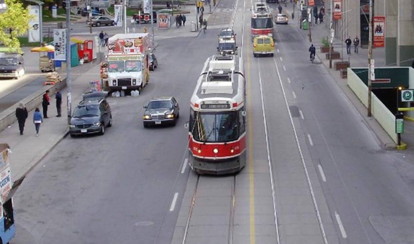 A street in Downtown Toronto, with a streetcar in the middle lane.