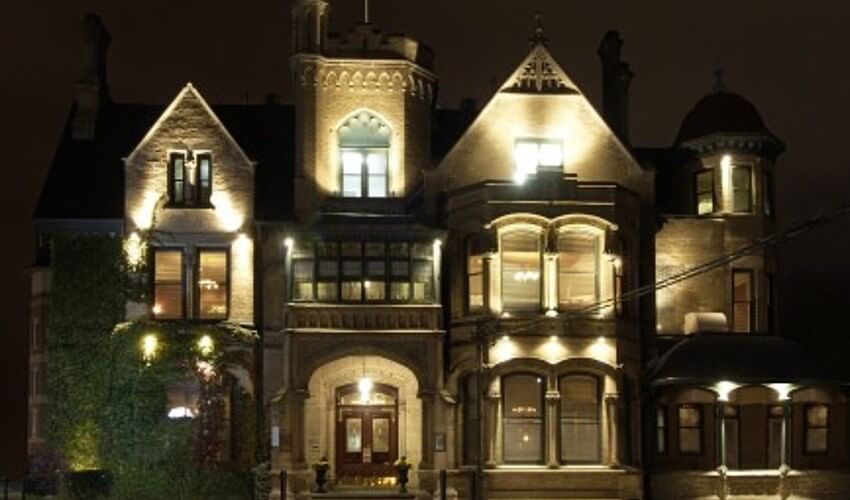 Exterior Keg Mansion lit up at night.
