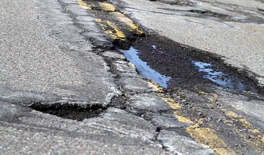 A pothole in the middle of two lanes.