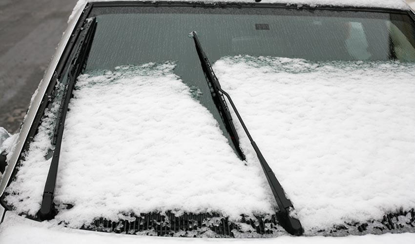 Snow partially covering a windshield.