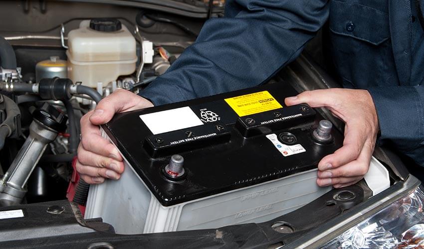 A mechanic installing a new car battery.