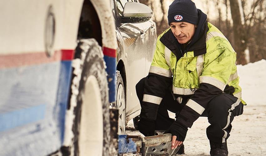 A close up of a CAA driver towing a car in winter.