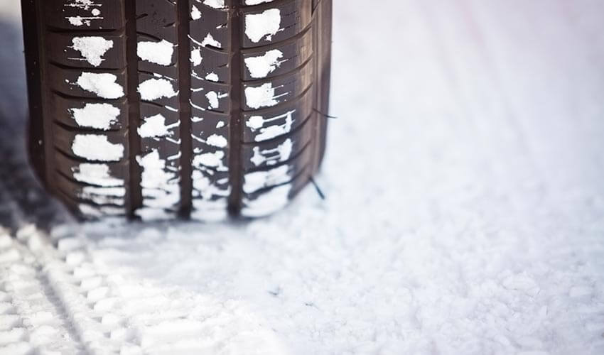 Close up shot of a car's tire in snow
