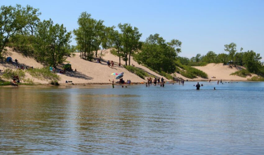 People enjoying the beach and sand dunes in Picton, Ontario.