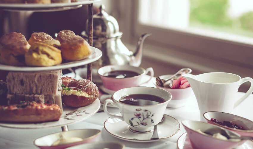 Afternoon tea for two with biscuits and sandwiches.