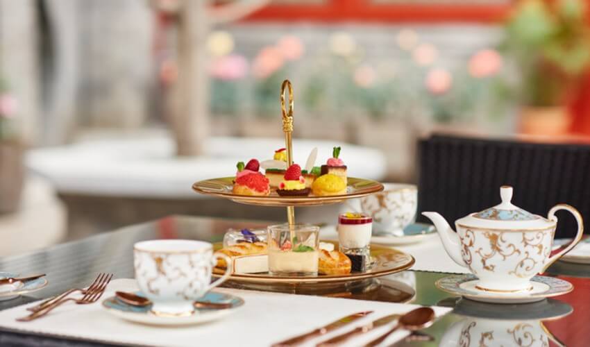 Afternoon tea in a garden with small pastries.
