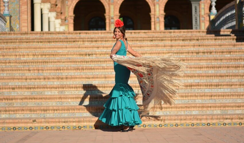Woman dancing flamenco with a green dress in Plaza de España, in Seville, Spain.