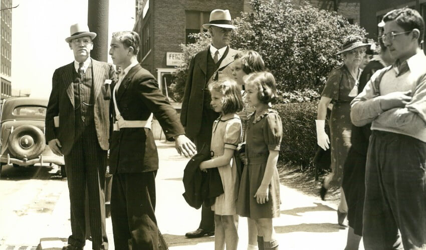 Historic photo of CAA School Safety Patroller helping peers cross the street.