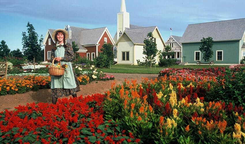 A woman holding a basket standing in front of Avonlea Village.