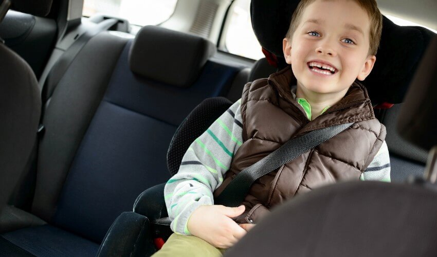 Happy little boy in a car safety seat. 